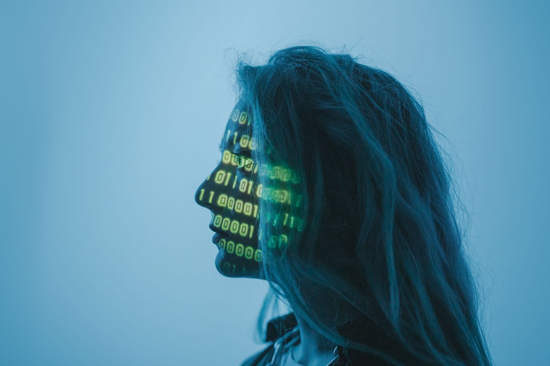 Sylwetka kobiety z kodem binarnym na twarzy symbolizująca cyberbezpieczeństwo Sylwetka kobiety z kodem binarnym na twarzy symbolizująca cyberbezpieczeństwo