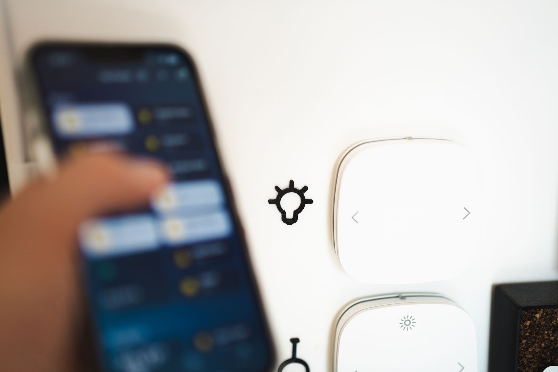 Smartfon sterujący urządzeniami smart home na ścianie